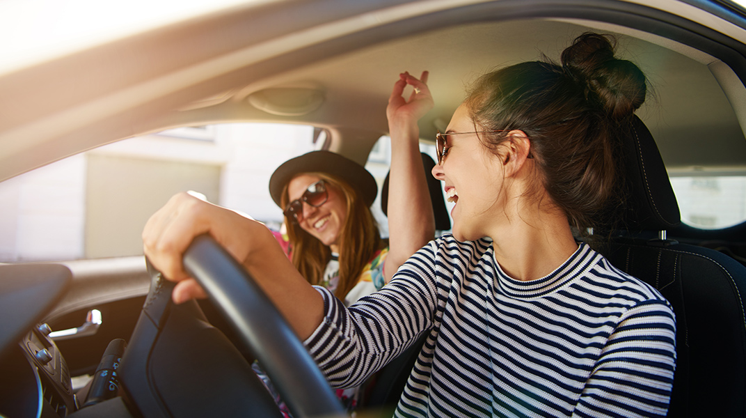 Two women in a car smiling and laughing